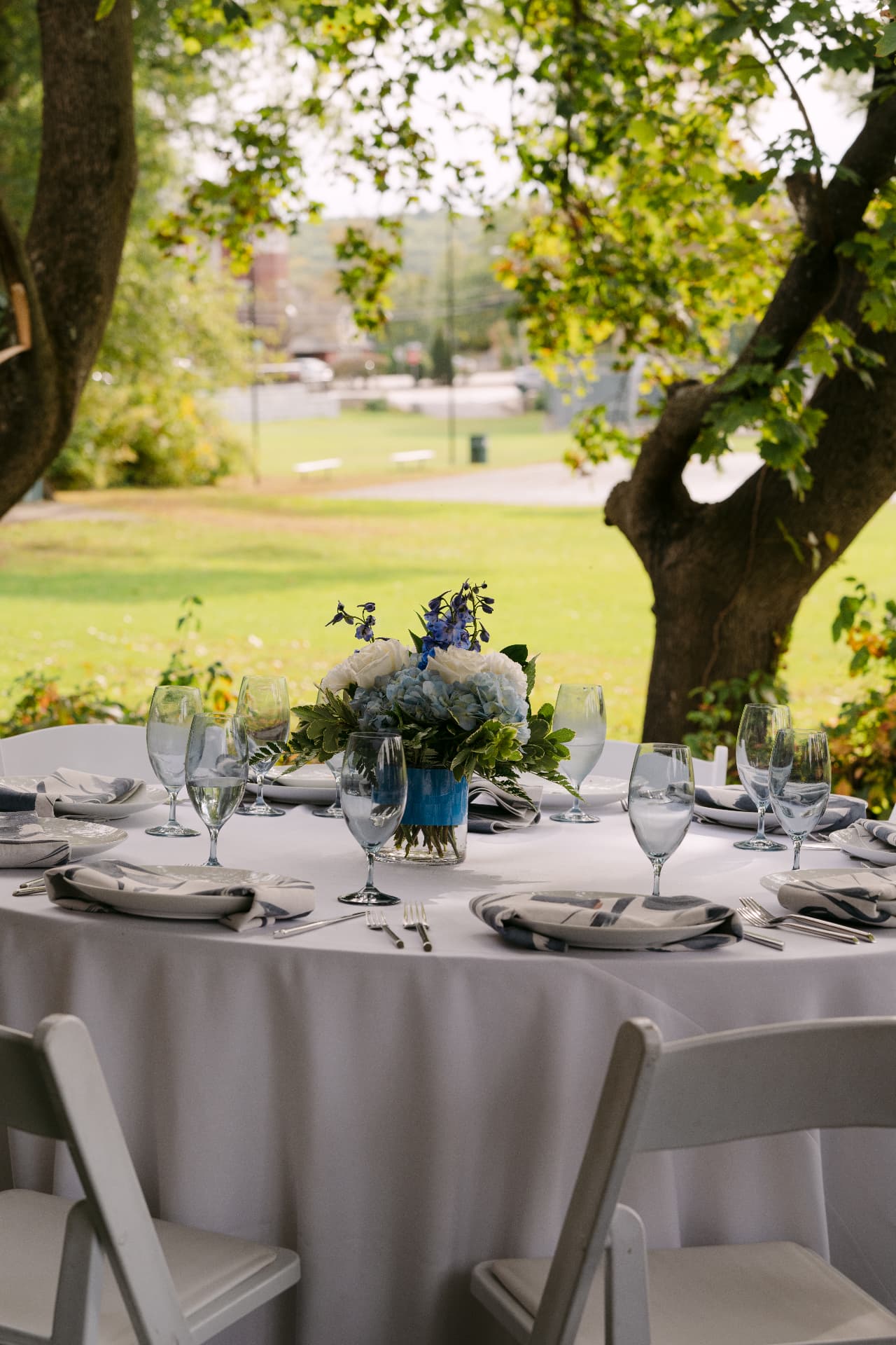 Outdoor reception table set with blue hydrangea centerpiece