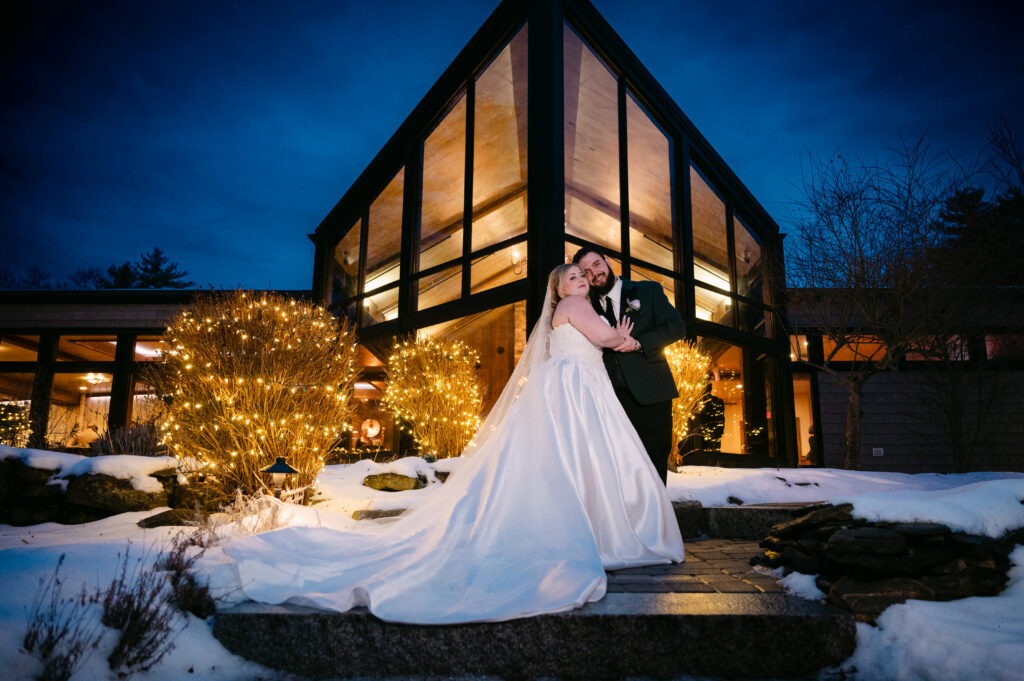 Snowy winter wedding at Birch Wood Vineyards in Derry New Hampshire with the reception building glowing at night