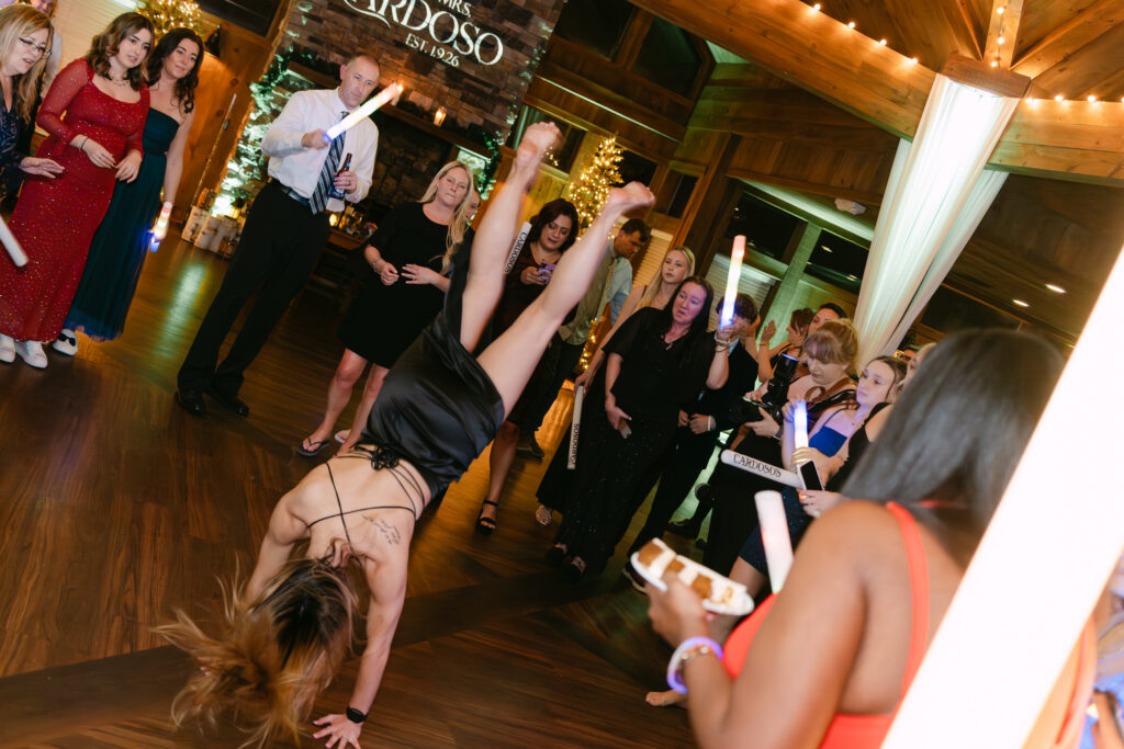 Wedding guests performing a cheer routine on the dance floor at Birch Wood Vineyards winter wedding in Derry New Hampshire